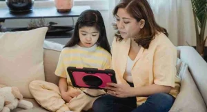 Parent helping a child return a tablet to the home screen before screen time ends