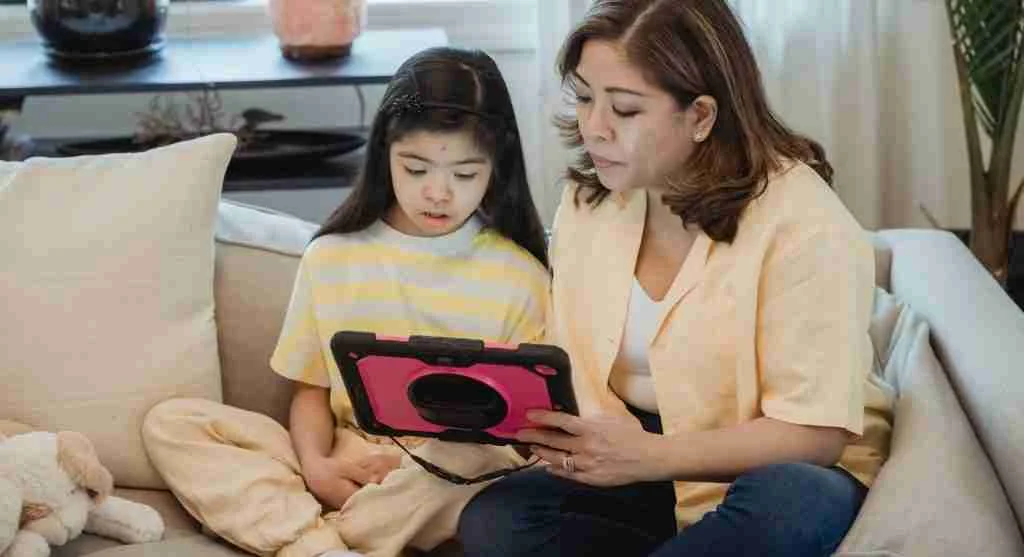 Parent helping a child return a tablet to the home screen before screen time ends