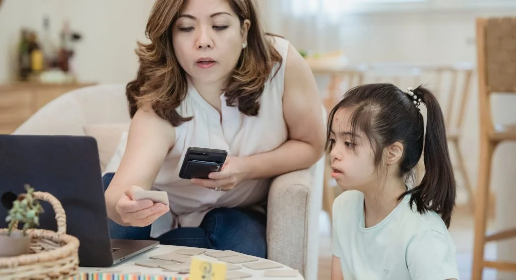 Parent guiding a child into the next activity after closing a device together