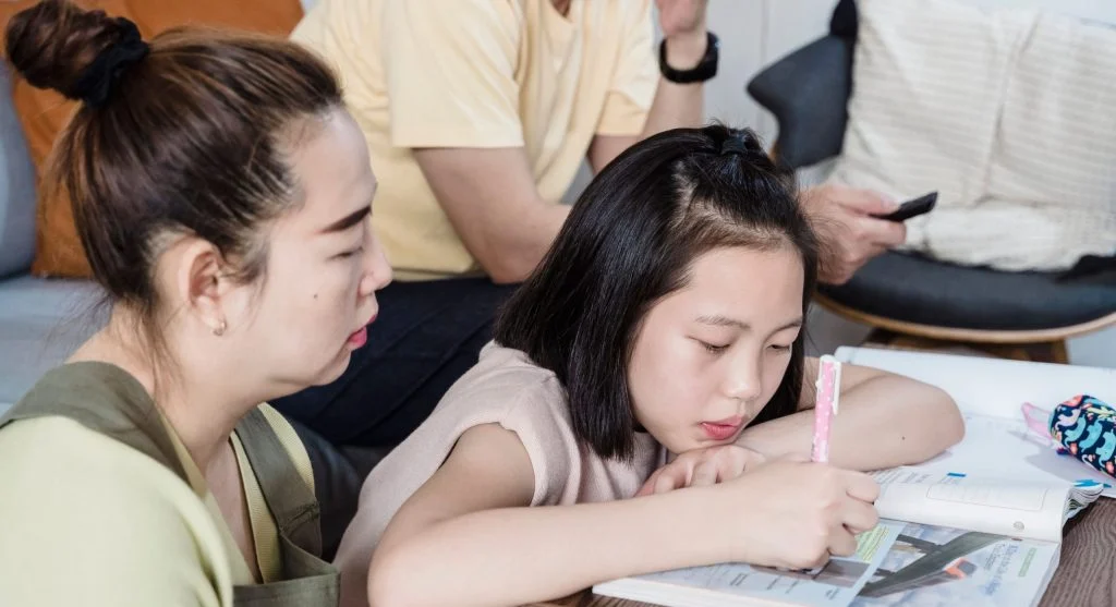 Parent helping a child connect homework directions to the correct first page