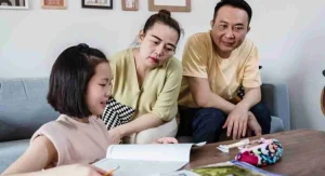 Parent helping a child compare two real objects side by side at home