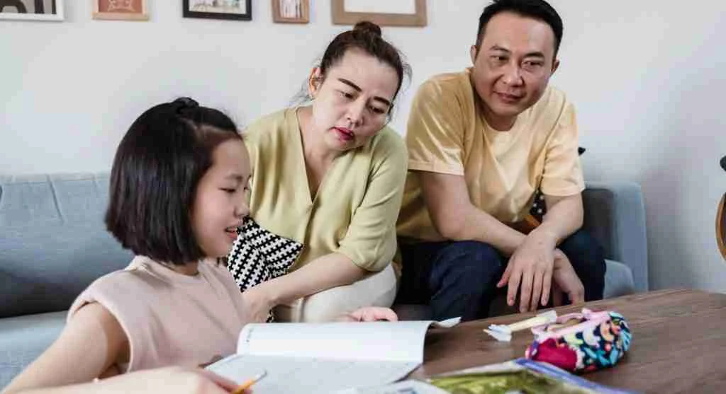 Parent helping a child compare two real objects side by side at home