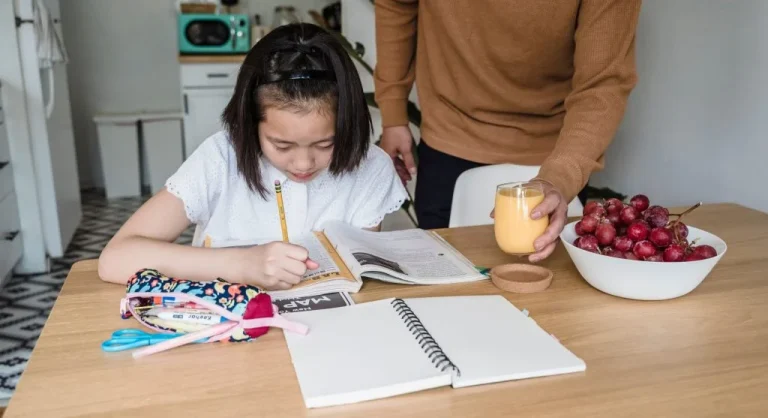 Parent helping a child focus on one learning example at a time during home study