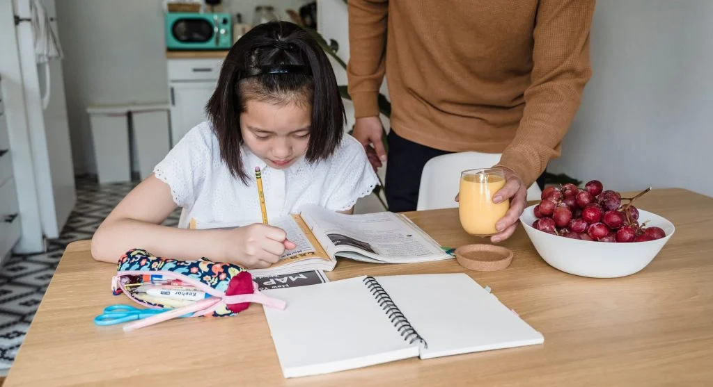 Parent helping a child focus on one learning example at a time during home study