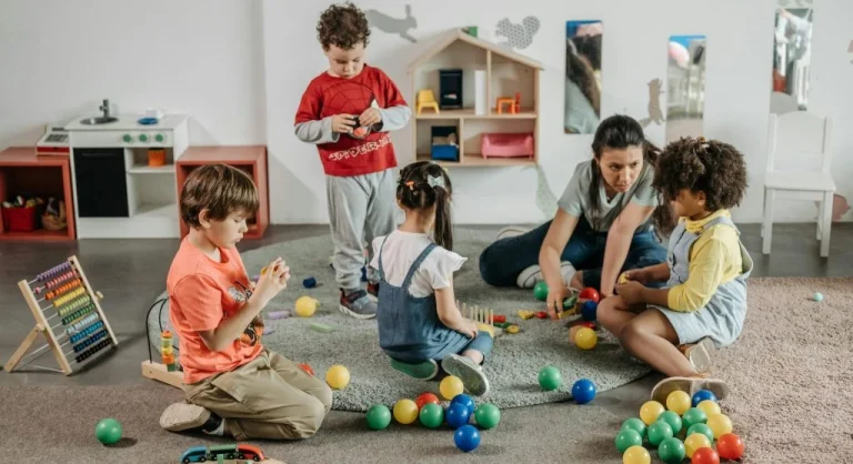 kids sharing toys with calm adult nearby