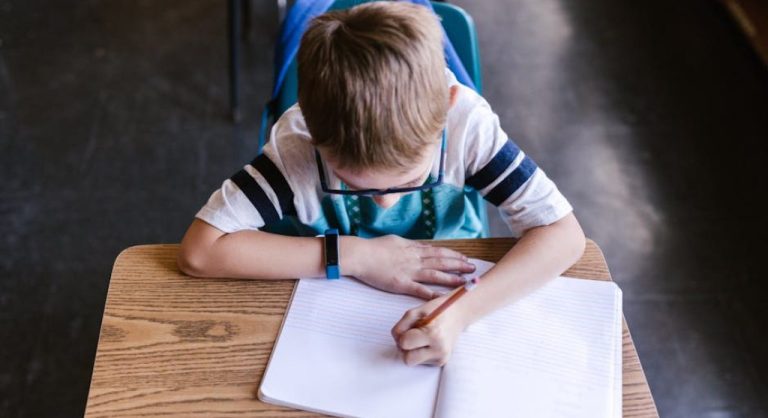 kid writing at desk