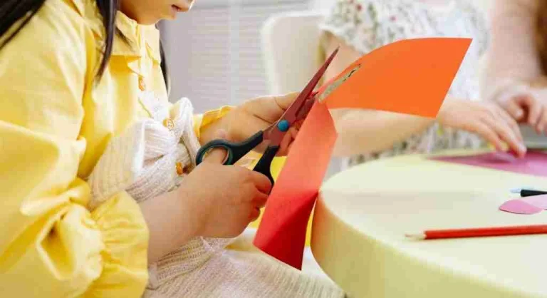 Child practicing scissor cutting while turning the paper during home learning